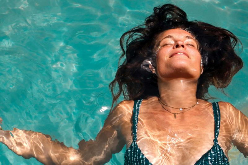 Entspannte Frau im Pool, Symbol für Entlastung, innere Ruhe und neue Stabilität